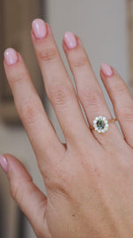 Video of a green sapphire and diamond halo ring on the hand, showing its scale, colour and antique-inspired proportions.
