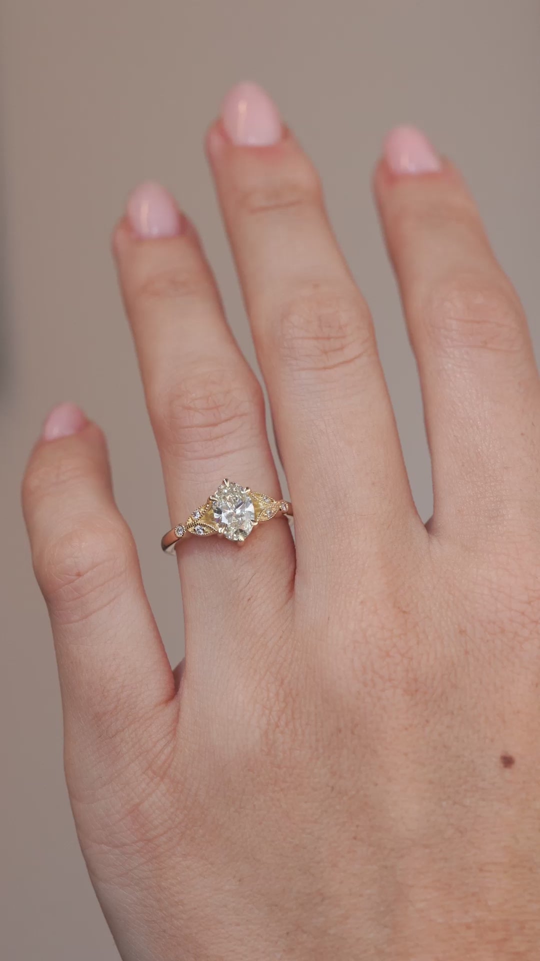 A hand-model video showcasing the pale yellow diamond and decorative gold shoulders.