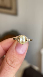 Close up video of a cushion-cut yellow sapphire set with diamonds in a yellow gold ring.  Vintage-inspired. 