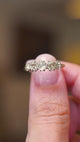 An Antique old-mine cut diamond five-stone ring with silver claws and yellow gold band being shown in a video between fingers.