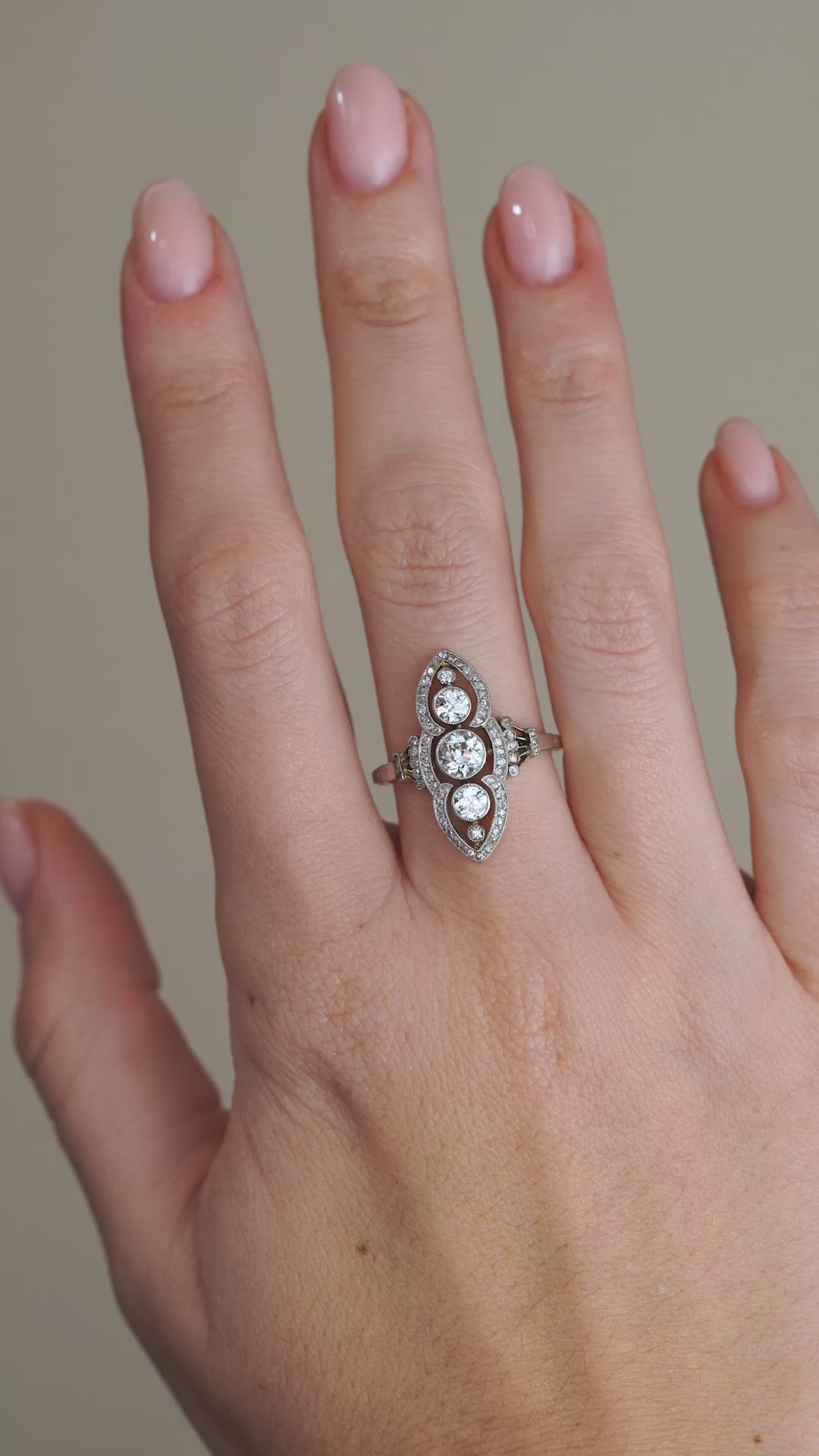 A video of the antique diamond ring worn on a hand, displaying its elegant Art Nouveau curves and intricate diamond detailing.
