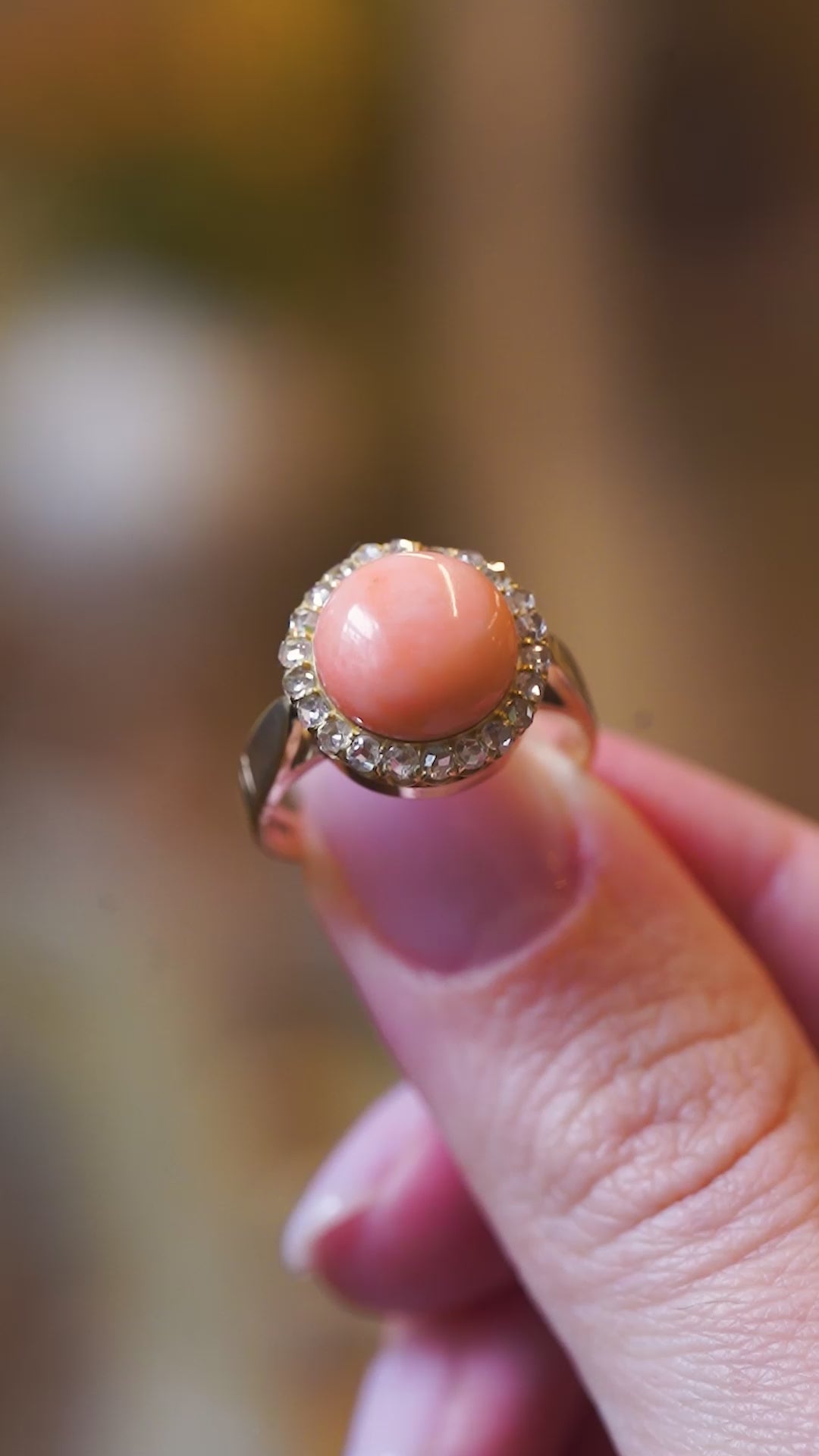 Victorian angel skin coral and diamond cluster ring showing coral cabochon and surrounding diamond detail.