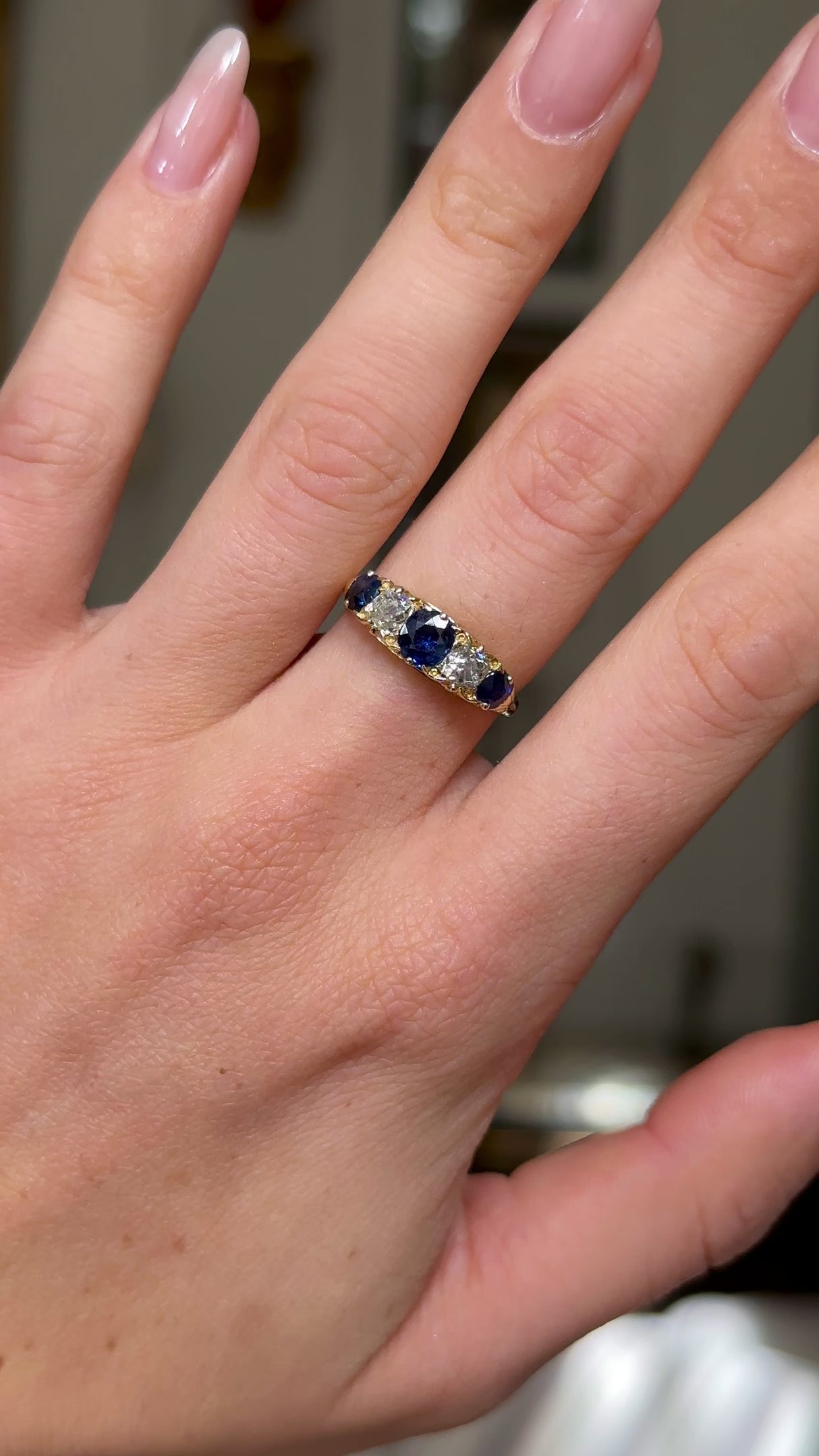 edwardian sapphire and diamond five stone ring worn on hand and moved away from lens to give perspective. 