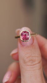 Video close-up of the sapphire ring balanced on a fingertip, highlighting its octagonal silhouette and clean setting.