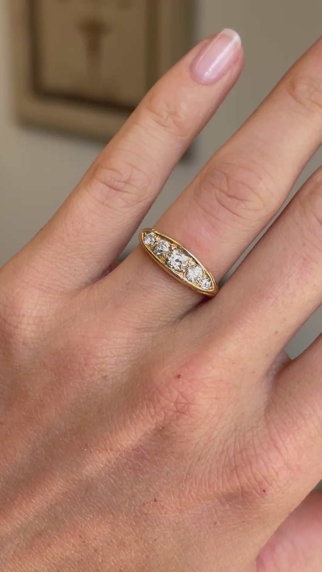 Antique Victorian old-mine cut diamond five-stone engagement ring featuring five graduated old-mine cut diamonds, displayed on a hand.