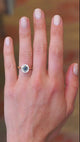 Teal sapphire cluster ring worn on hand showing colour shift and natural movement.
