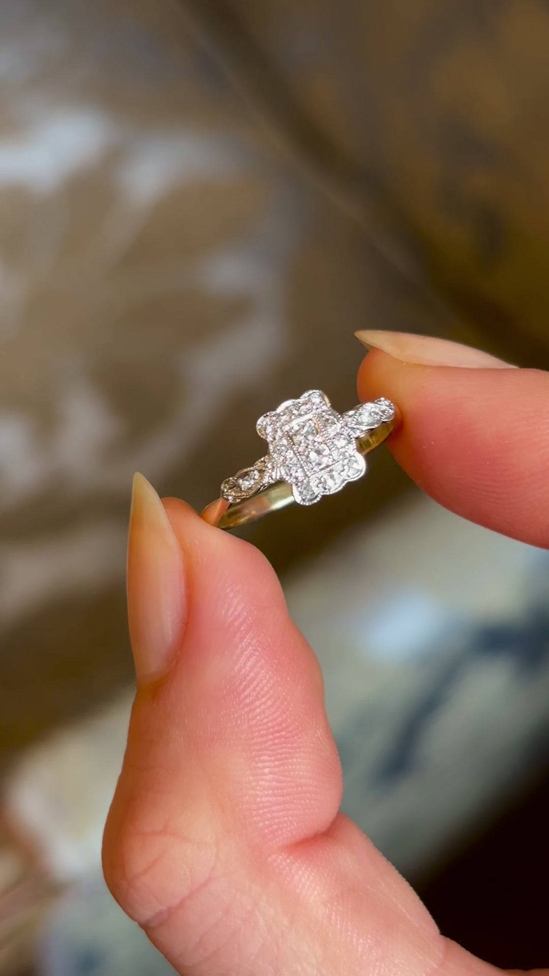 Antique, Edwardian diamond panel cluster engagement ring held in fingers and moved around to show fine details