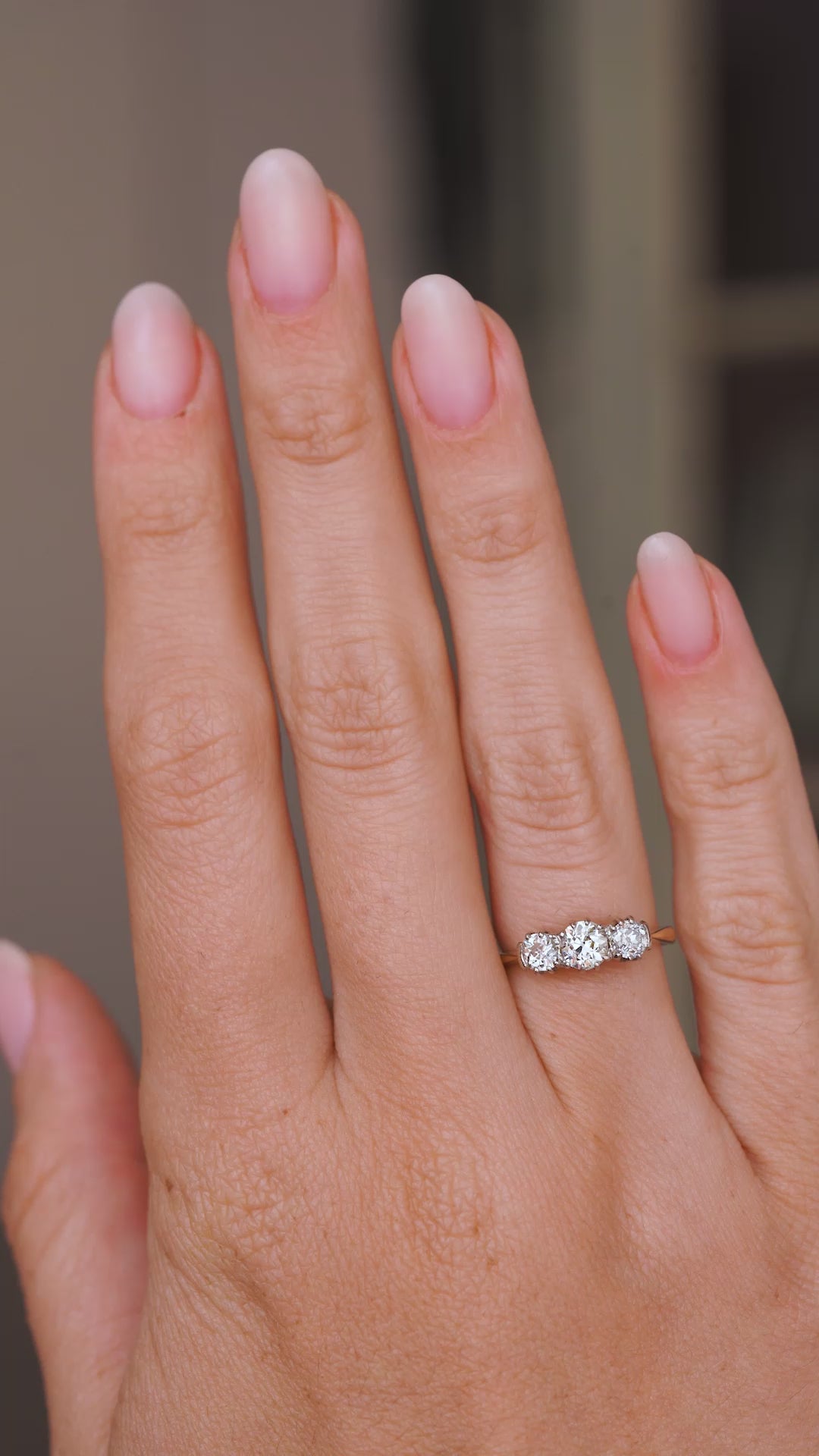 A video of a yellow gold Antique, Edwardian diamond three-stone engagement ring worn on the hand