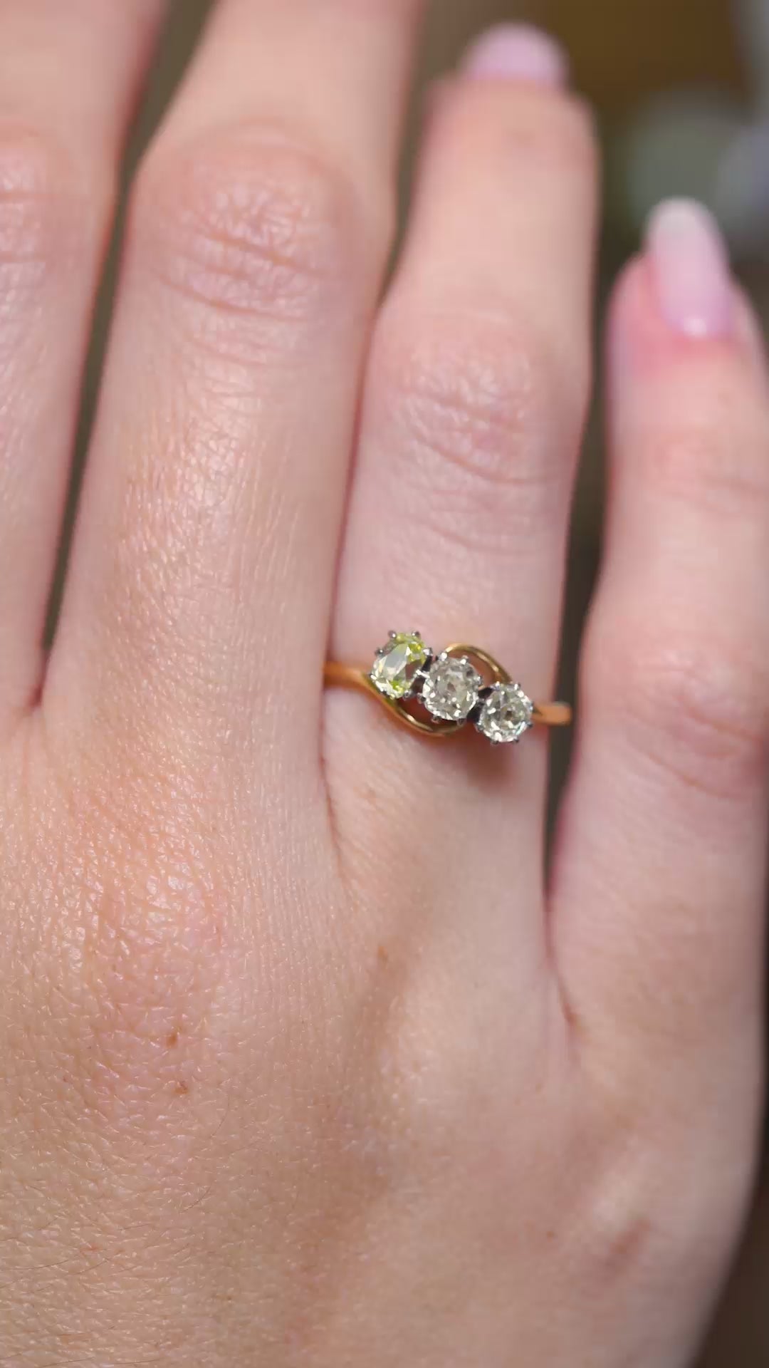 A video of an Antique Art Nouveau diamond three-stone ring worn on the hand