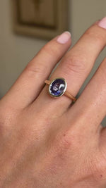 A close-up video of an antique-inspired, royal purple oval sapphire solitaire ring in yellow gold shown on a hand.