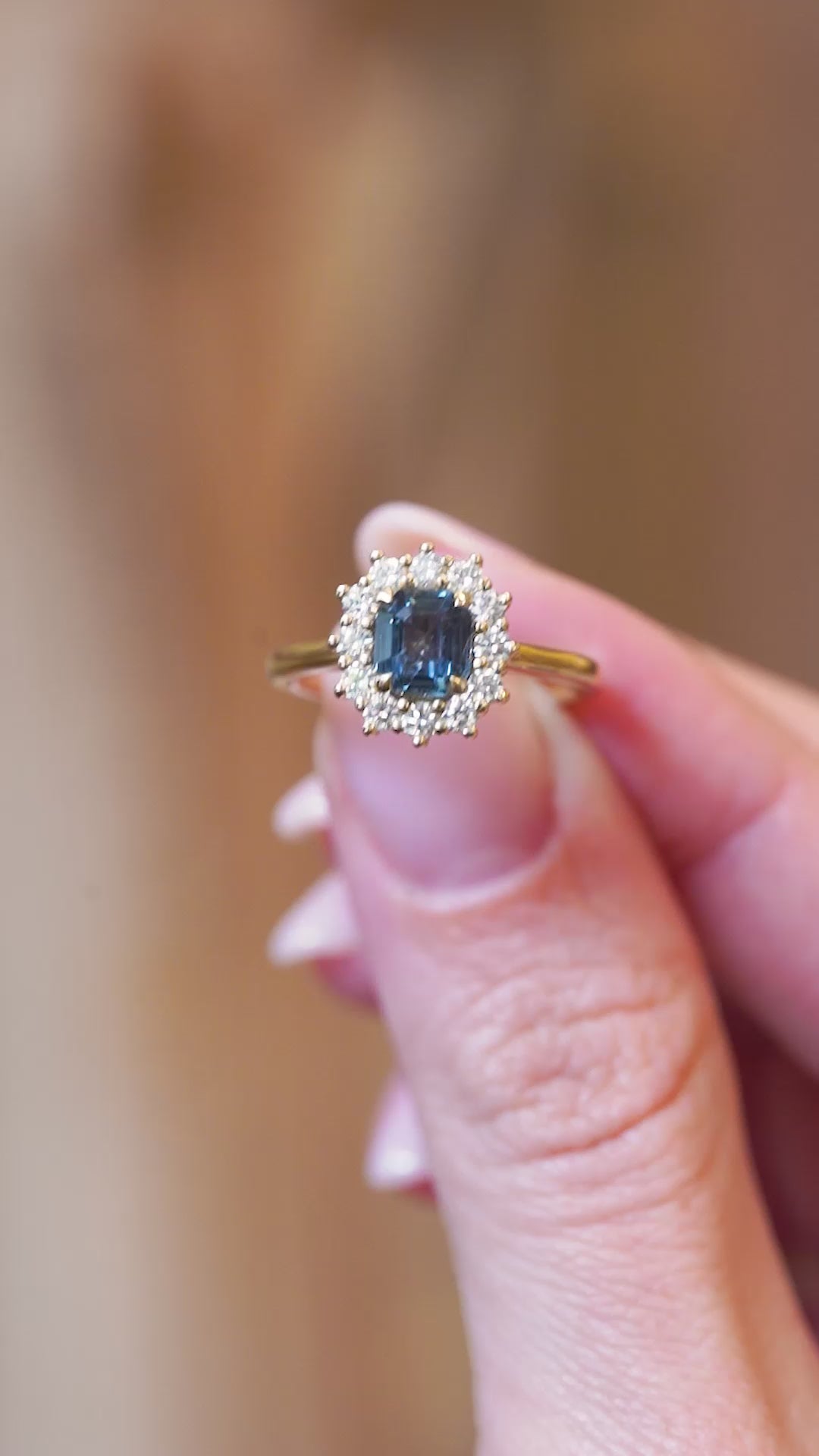 Close detail video of teal sapphire and diamond cluster engagement ring with sparkling diamonds.