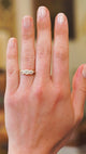 Three stone diamond ring worn on hand showing soft sparkle and natural movement.