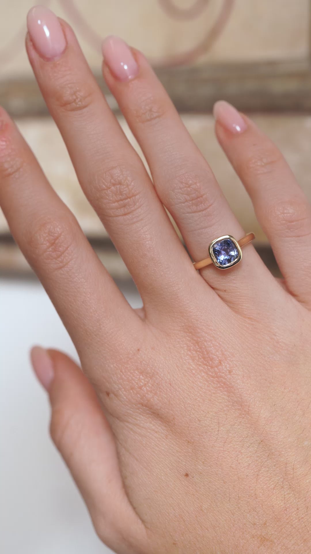 A video of the blue sapphire solitaire ring worn on a finger, capturing the gemstone's vibrant blue tones and sparkle.