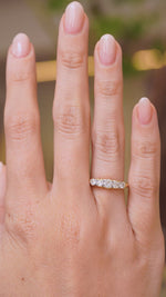 A video showing a hand wearing a Antique, Victorian diamond five-stone engagement ring, against a softly blurred interior background
