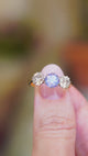 Sapphire ring with diamond side stones showing light reflections and three stone design.