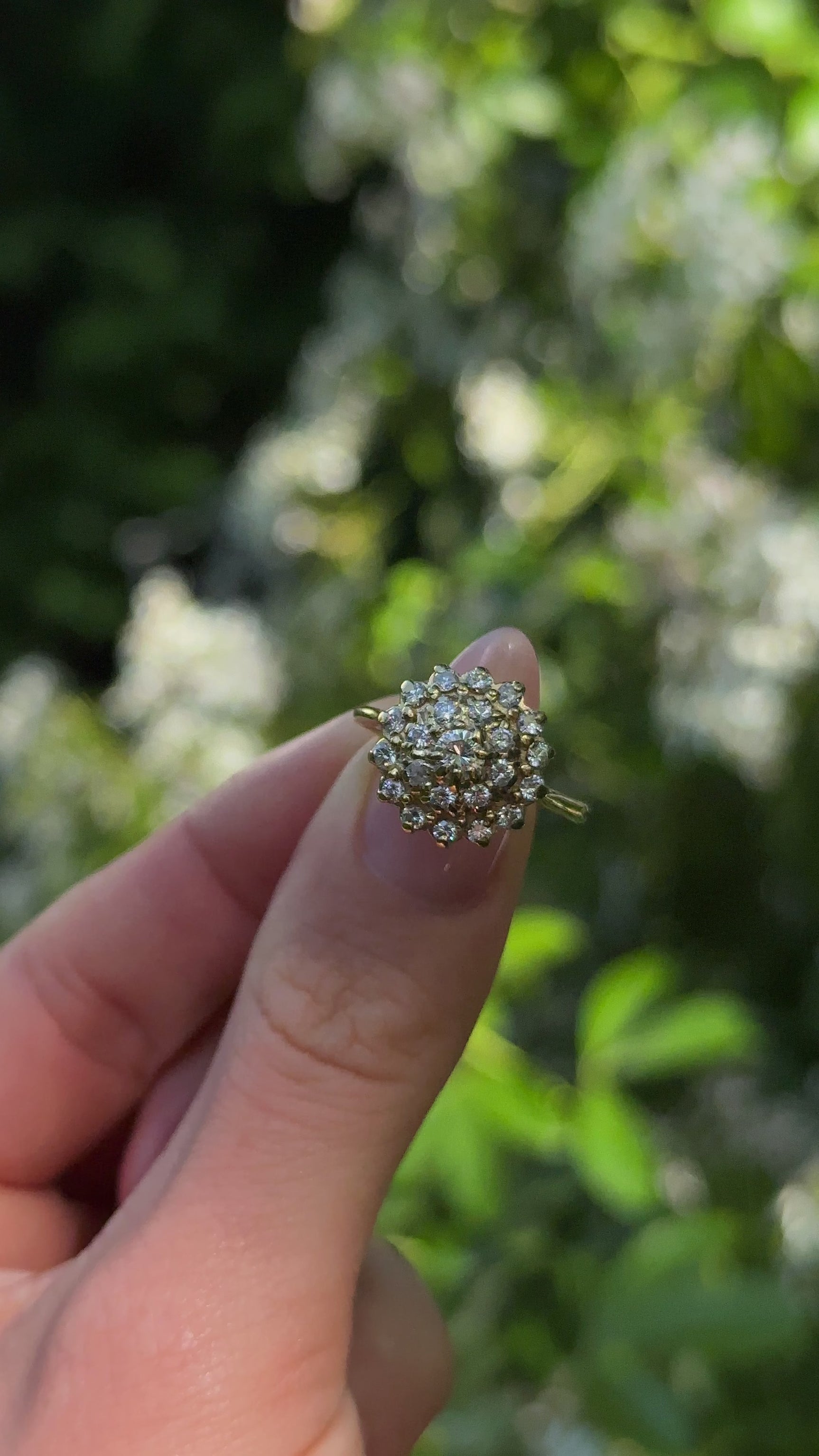 Vintage, 1970s Large Diamond Cluster Ring, 18ct Yellow Gold held in fingers and rotated to give perspective.