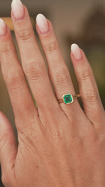 A video of a hand wearing a yellow gold Antique-inspired, Emerald solitaire engagement ring and showing off the scale.