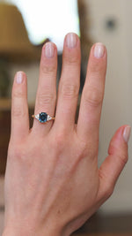 Teal sapphire ring worn on hand showing blue green colour shift and natural movement.