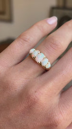 An Antique Australian oval opal five-stone ring shown on a hand in video.