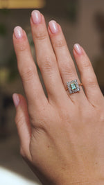 Video of an antique Edwardian emerald cluster ring worn on the hand, capturing the pale green gemstone and old-mine diamond sparkle.