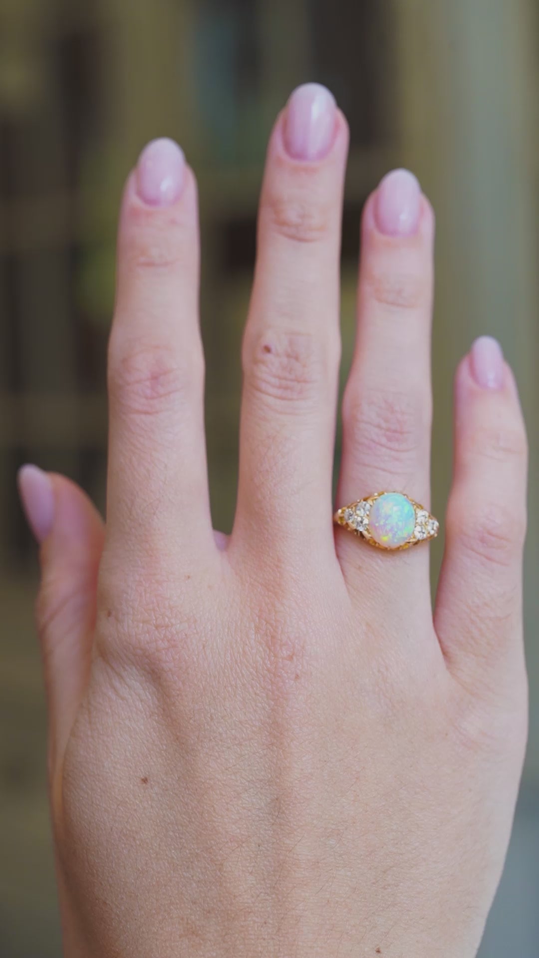Antique Victorian opal and diamond ring worn on hand showing opal play of colour in natural movement.