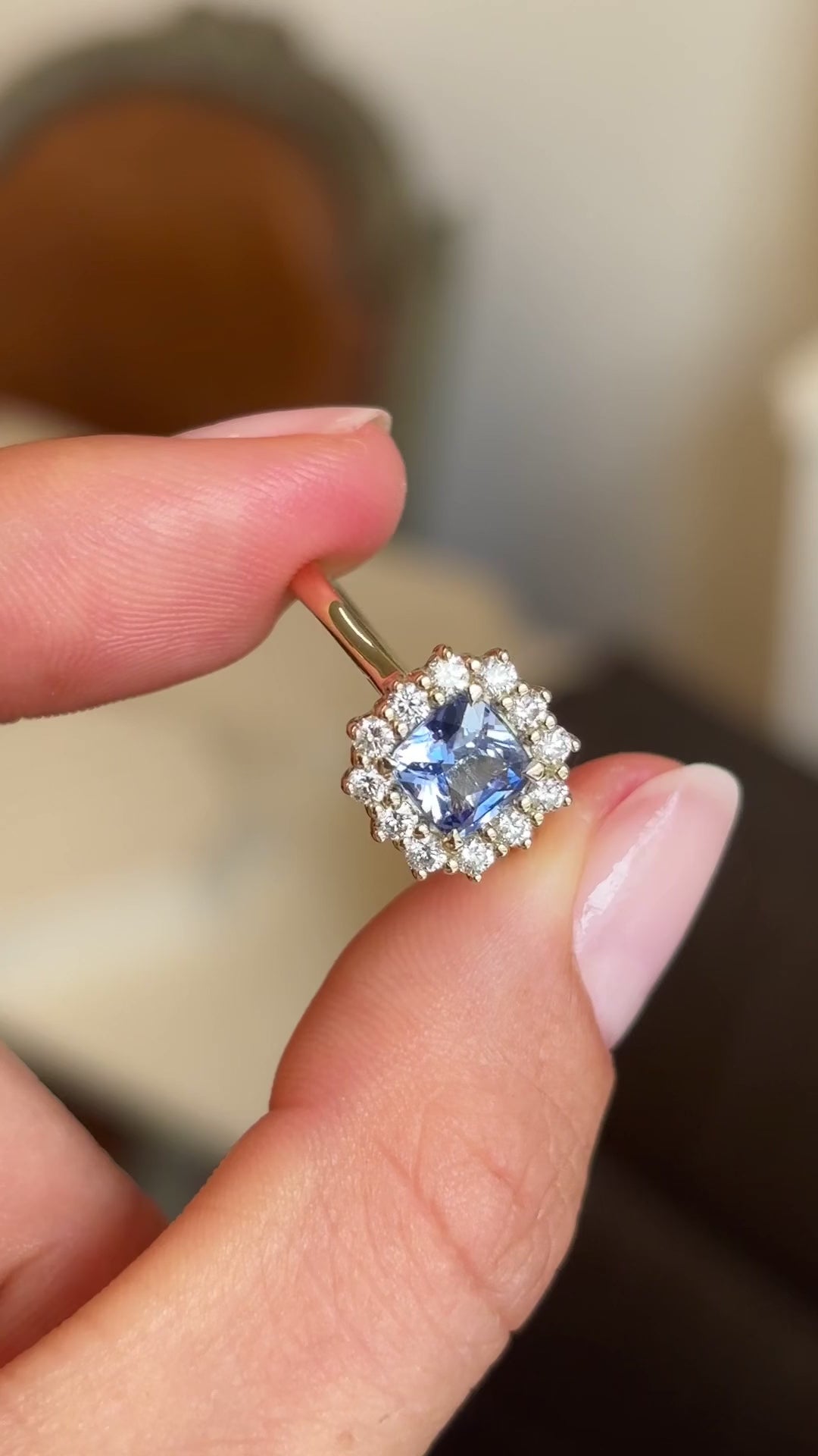 Video of an Antique-inspired, Cornflower-blue sapphire and diamond cluster engagement ring, showcasing the cushion-cut of the central sapphire and the yellow gold band. 