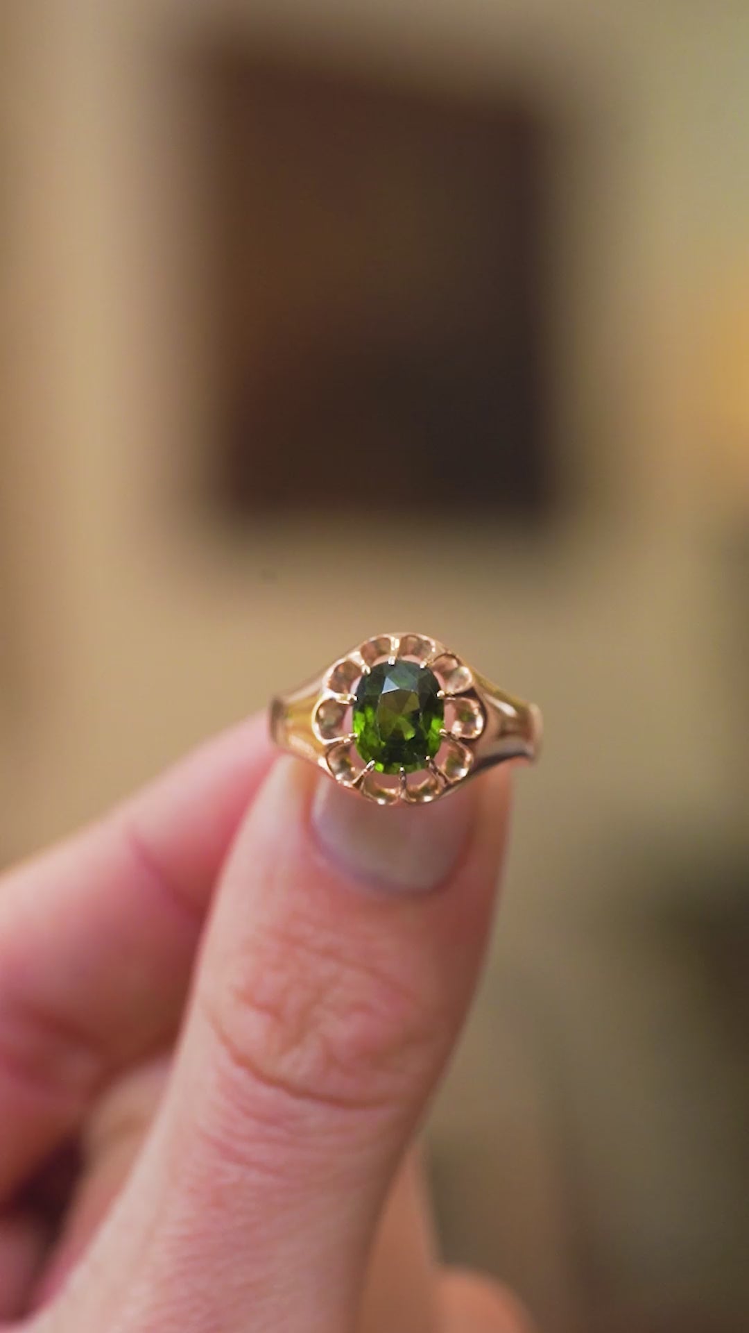 Aantique zircon ring showing deep green stone and open gold setting detail.