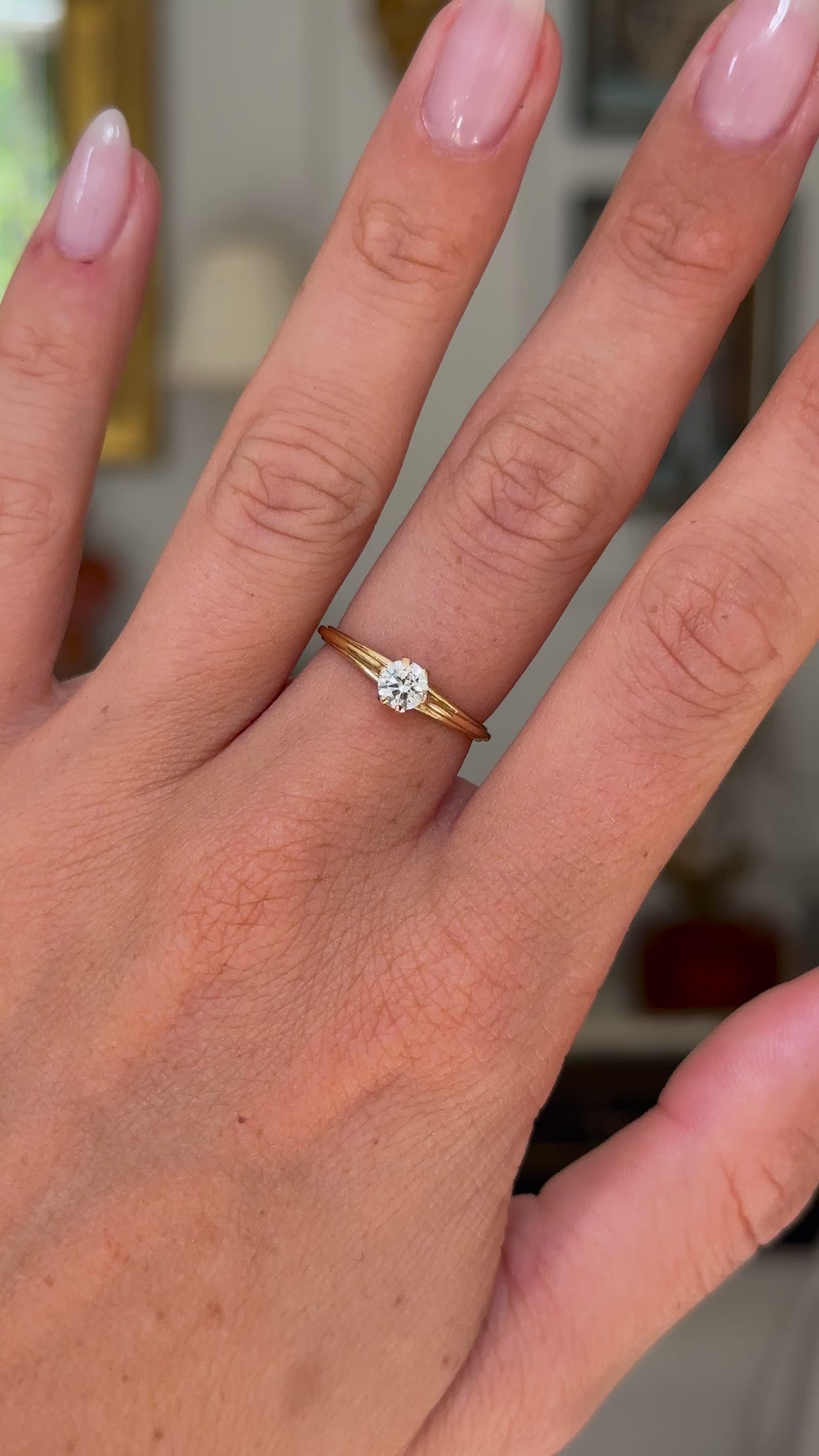 Vintage solitaire diamond engagement ring worn on hand and moved around to give perspective.