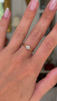 Vintage solitaire diamond engagement ring worn on hand and moved around to give perspective.