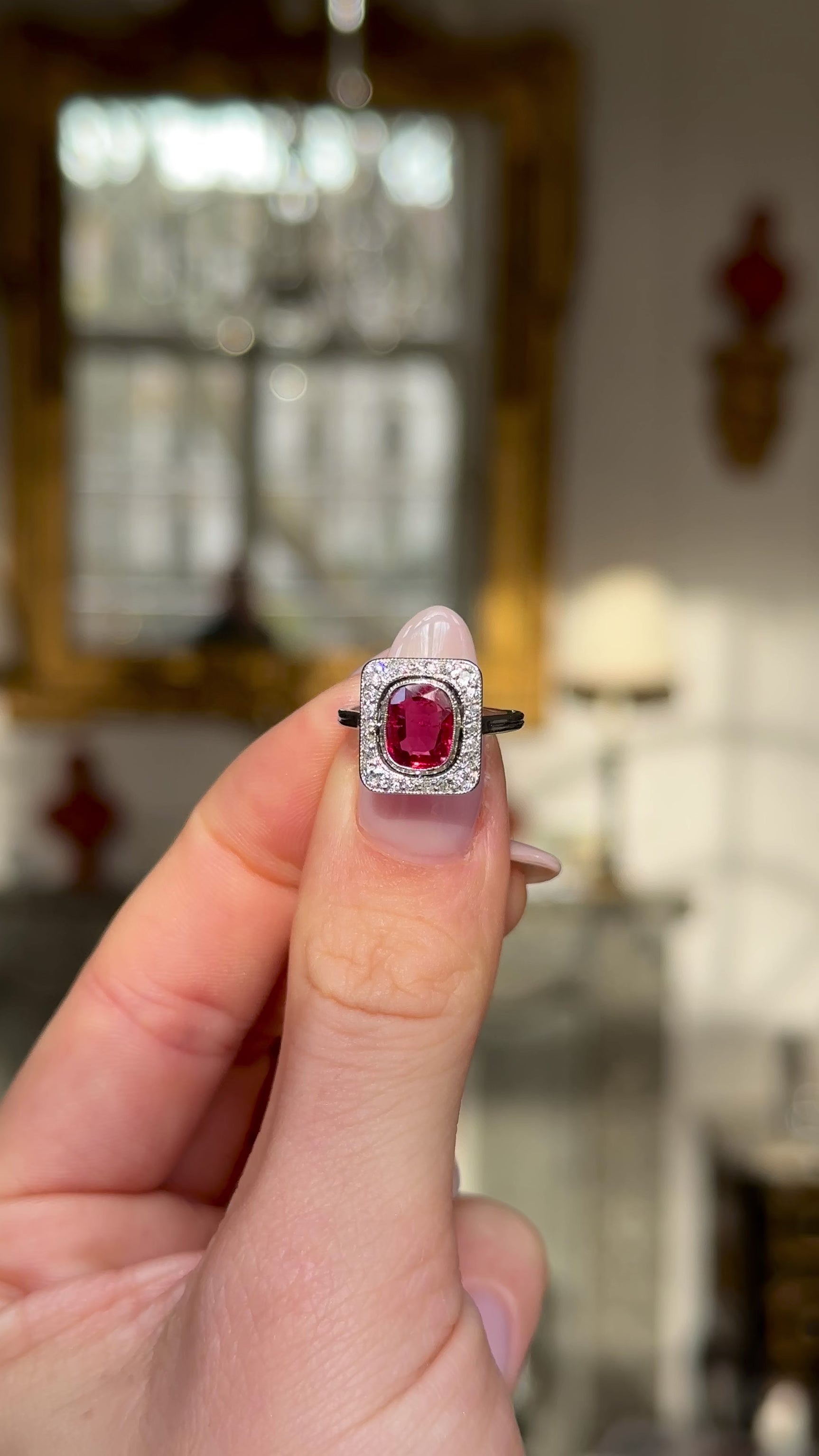 Vintage Art Deco ruby and diamond engagement ring held in fingers and moved around to give perspective.