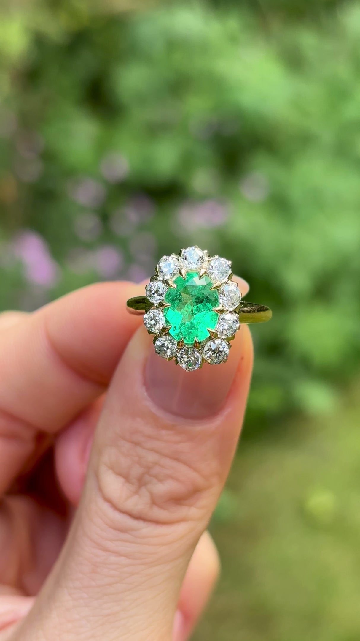 Vintage, Emerald and diamond cluster ring, 18ct yellow gold held in fingers