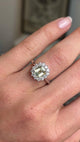 video of an Antique inspired, yellow sapphire and diamond cluster engagement ring in platinum worn on a wedding finger against a blurred background