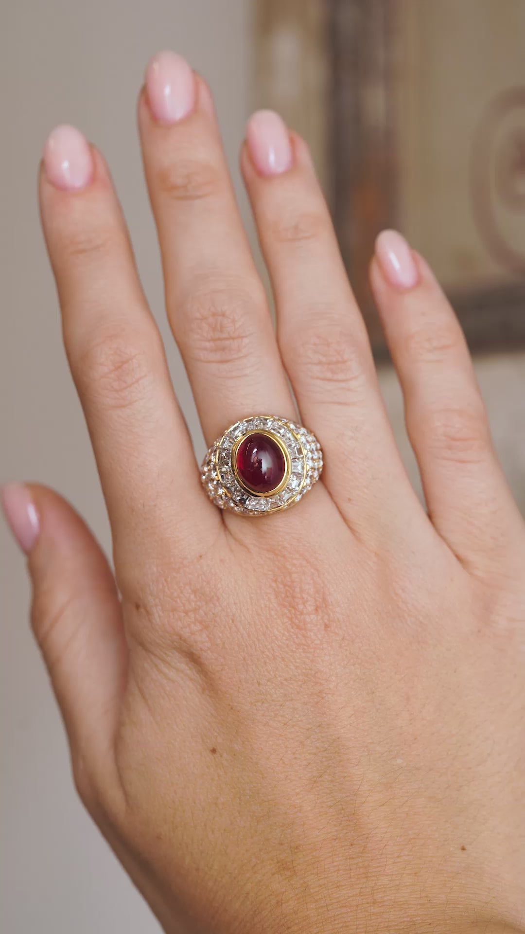 Video of the vintage Asprey cocktail ring on the hand, capturing the deep red cabochon ruby and brilliant diamond sparkle.
