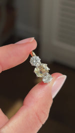 Vintage 1970s yellow sapphire and old-cut diamond three-stone engagement ring featuring an emerald-cut yellow sapphire and old-cut diamond side stones, held by hand for detailed viewing.