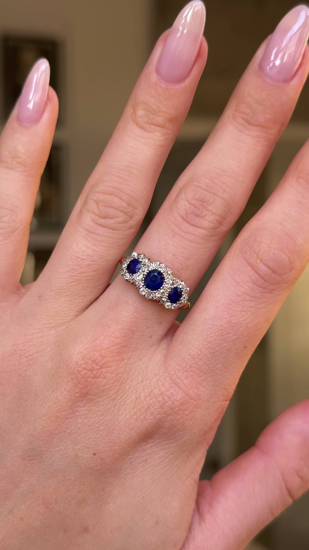 sapphire and diamond triple cluster ring worn on hand and moved arund to give perspective.