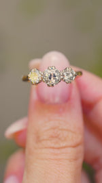 A video of the front view of three graduated old-cut diamonds held on the finger and thumb.