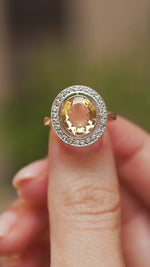 Video close-up of a French Belle Époque citrine and diamond ring balanced on a fingertip, highlighting its ornate antique cluster design.