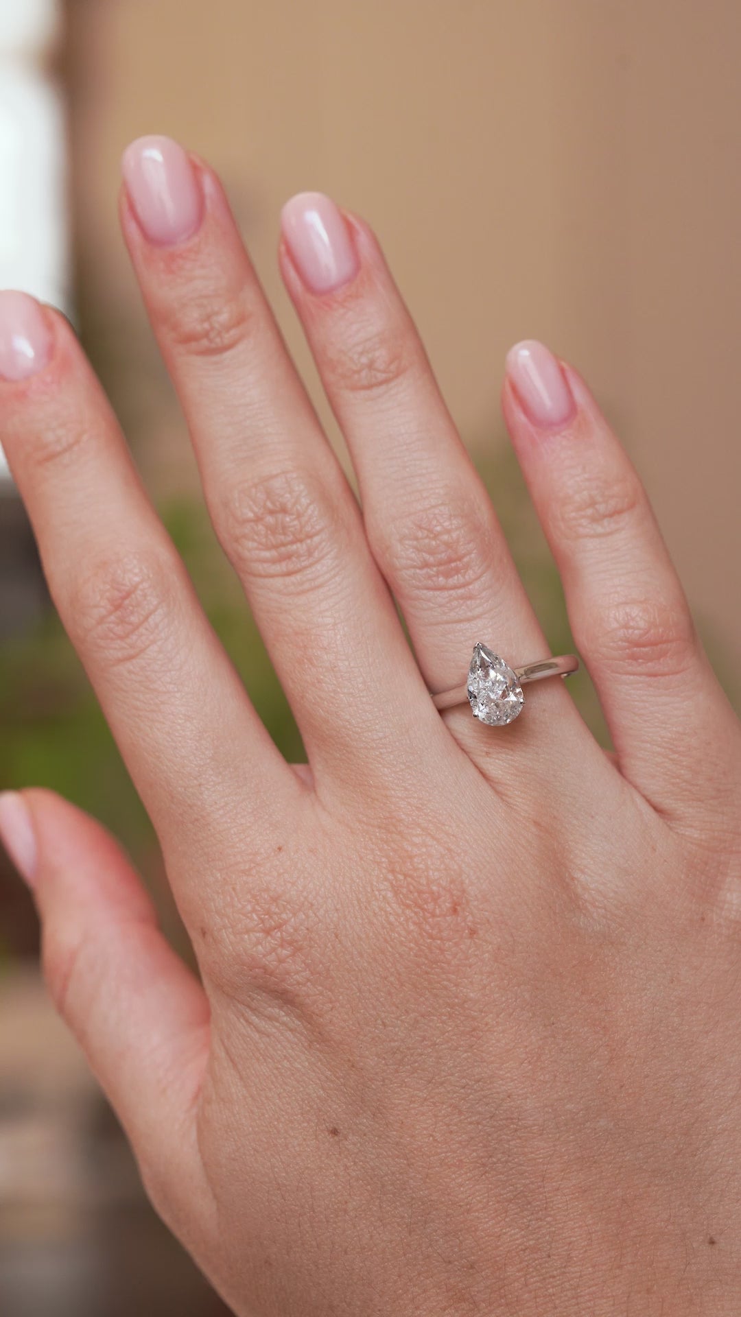 Video of a vintage pear-cut diamond engagement ring worn on the hand, highlighting its distinctive salt and pepper inclusions.