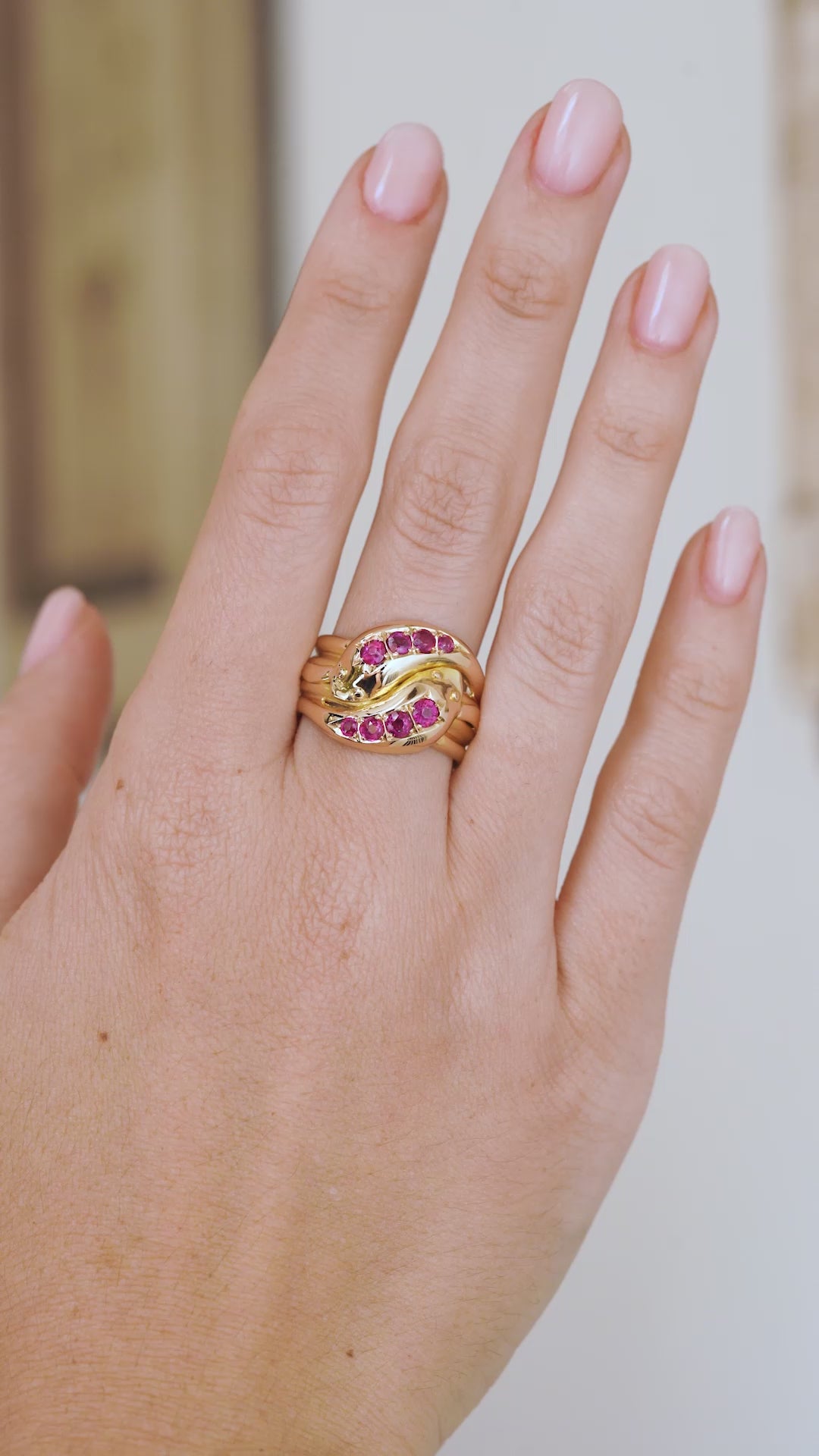Video of the antique Victorian snake ring on the hand, highlighting the natural ruby details and polished gold movement.
