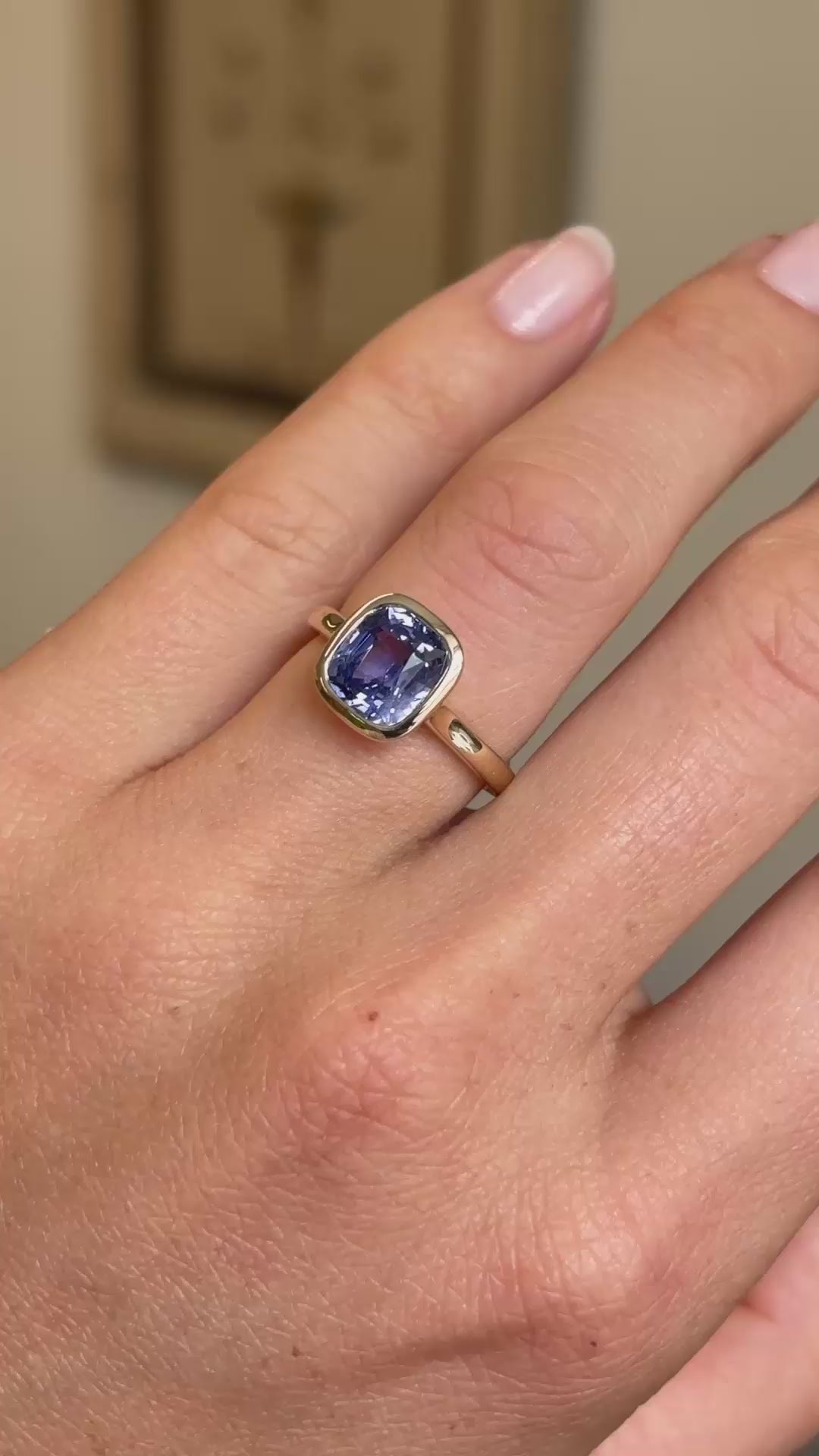 A video of a close-up of an Antique-inspired, vivid violet sapphire solitaire engagement ring set in yellow gold worn on a hand.
