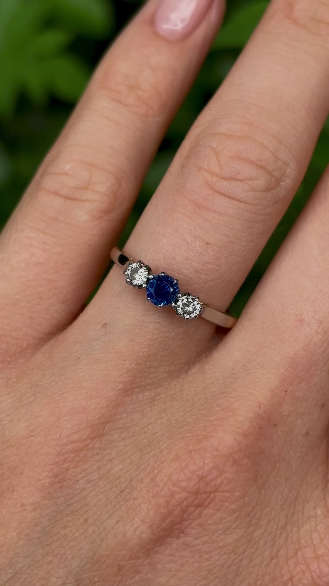 Antique, Edwardian sapphire and diamond three-stone ring worn on hand.