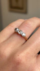 Antique Edwardian three-stone ring in yellow gold worn on hand, featuring old-cut brown, pink and champagne coloured diamonds, filmed against a softly lit vintage interior backdrop.