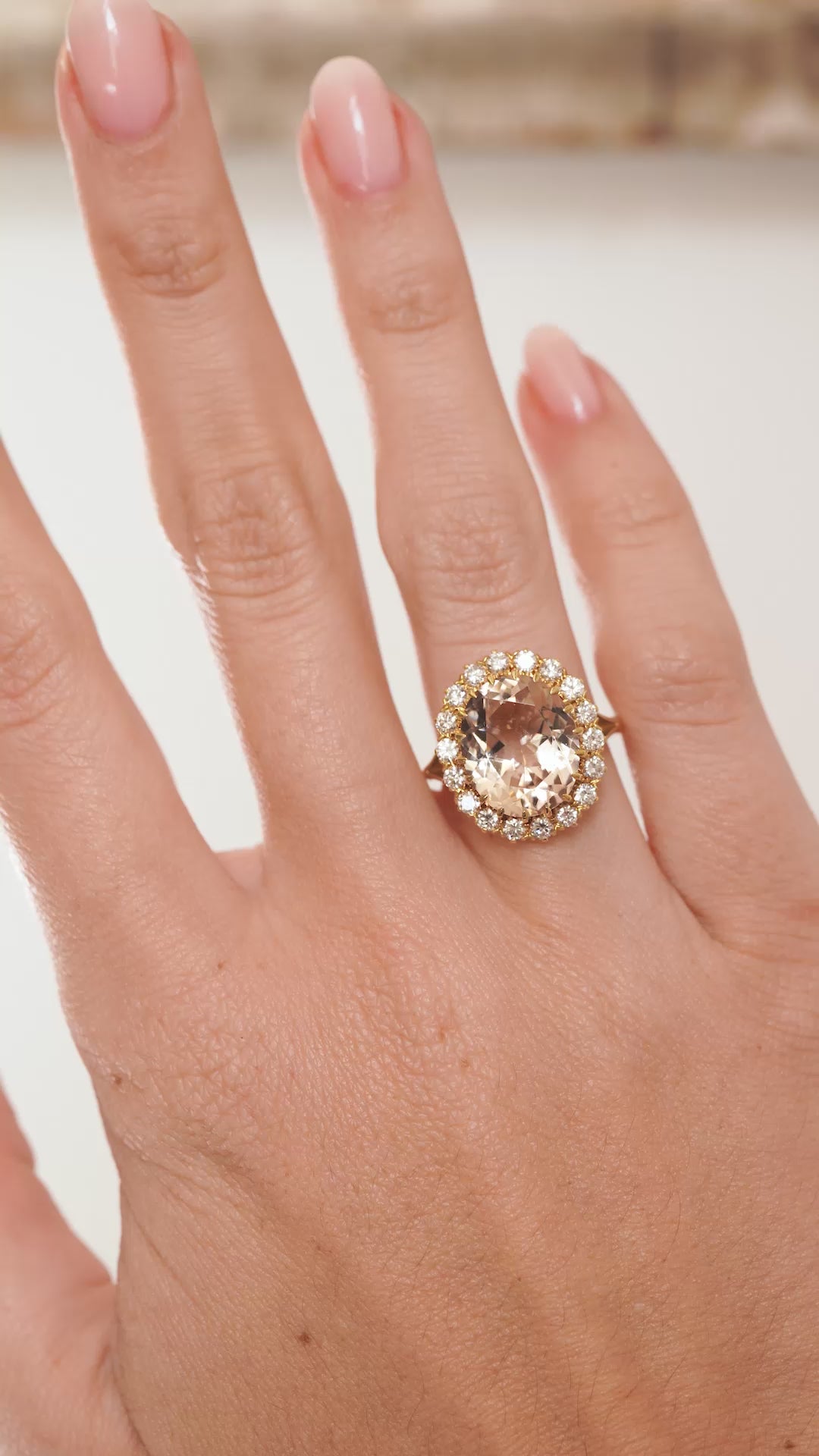 Video showcasing the oval-cut topaz and diamond halo ring on the hand as the gemstones catch the light.