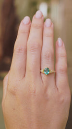 video of Vintage-inspired, Emerald and diamond engagement ring worn on the hand at a distance to show scale