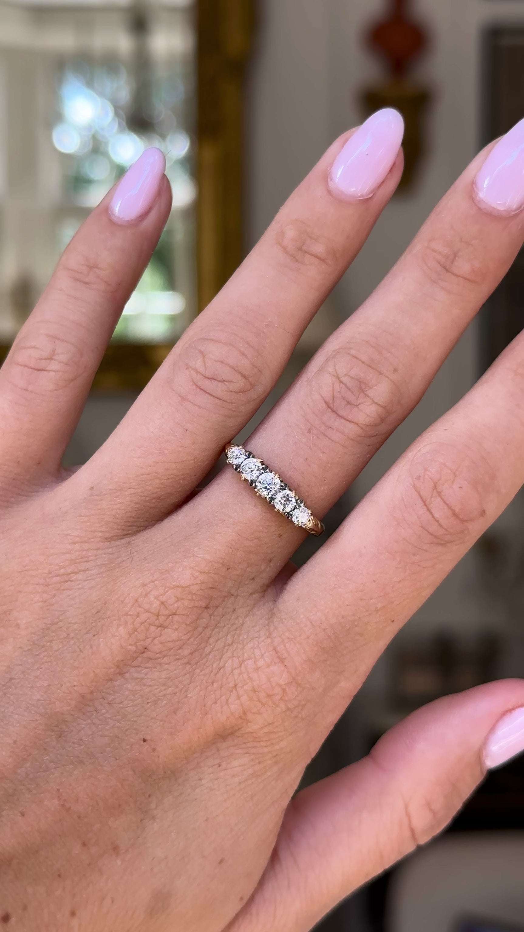 Edwardian diamond and 18ct yellow gold half hoop ring, worn on hand and moved away from lens to give perspective,, front view. 