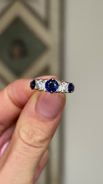 Antique, Victorian sapphire and diamond five-stone ring held in fingers.