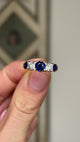 Antique, Victorian sapphire and diamond five-stone ring held in fingers.