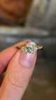 Diamond three-stone engagement ring held in fingers and rotated to show details