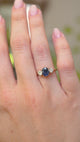 A video of an Antique, Art Deco sapphire and diamond trilogy engagement ring mounted on a yellow gold band and worn on the hand as its moved.