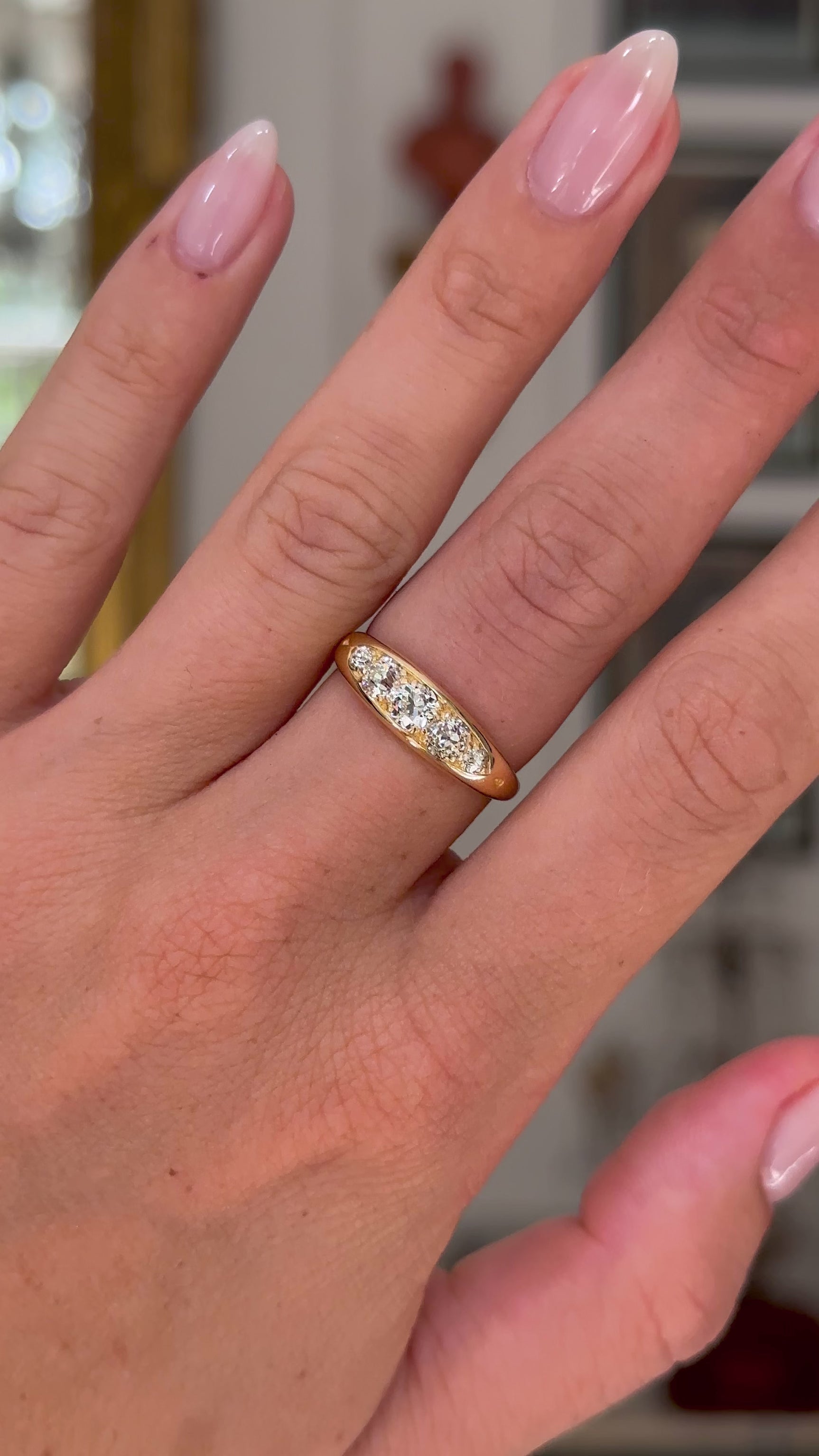 Antique five stone diamond engagement ring, worn on hand and moved away from lens to give perspective,front view.